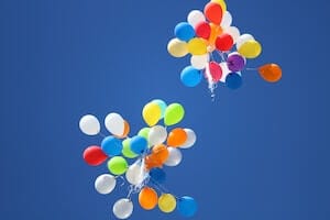 Dieses Bild zeigt farbige Ballons, die in den blauen Himmel fliegen. Dieses Bild soll ein Symbol für Familien sein. Aber auch für Patchwork Familien, oder für Paare, die einen Kinderwunsch haben.